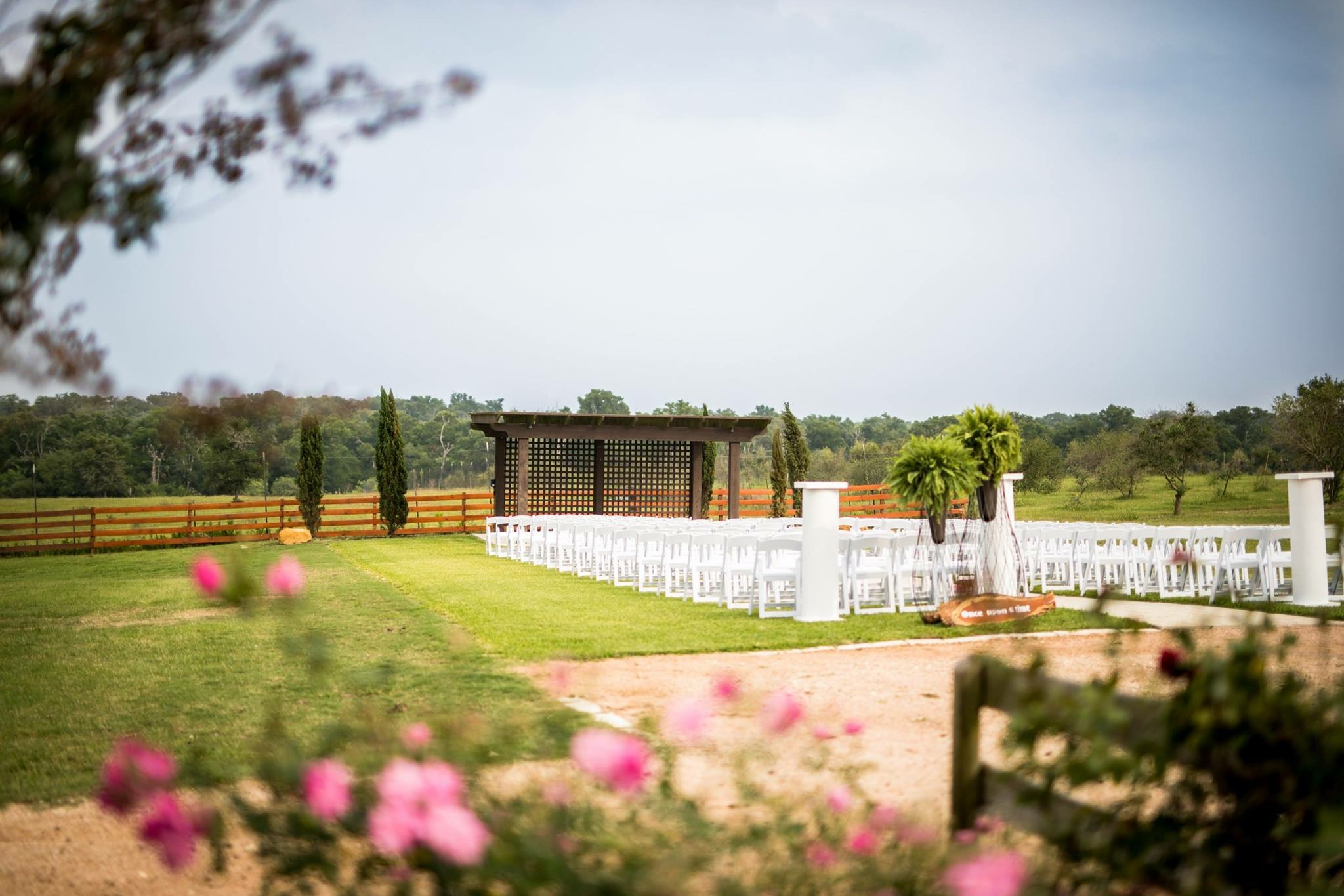 Outdoor ceremony space framed by flowers and vineyard grounds