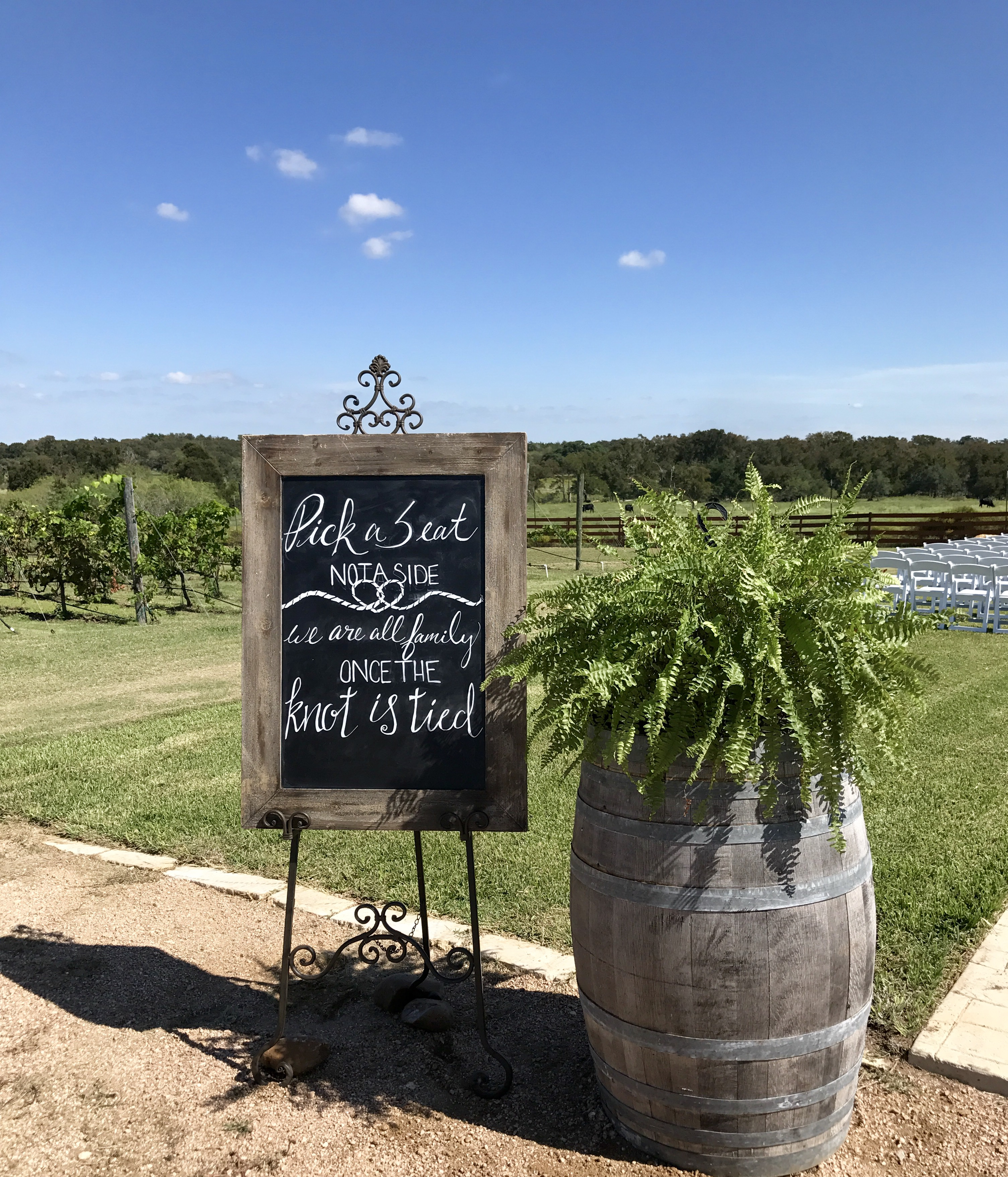 Chalkboard sign welcoming guests beside the vineyard