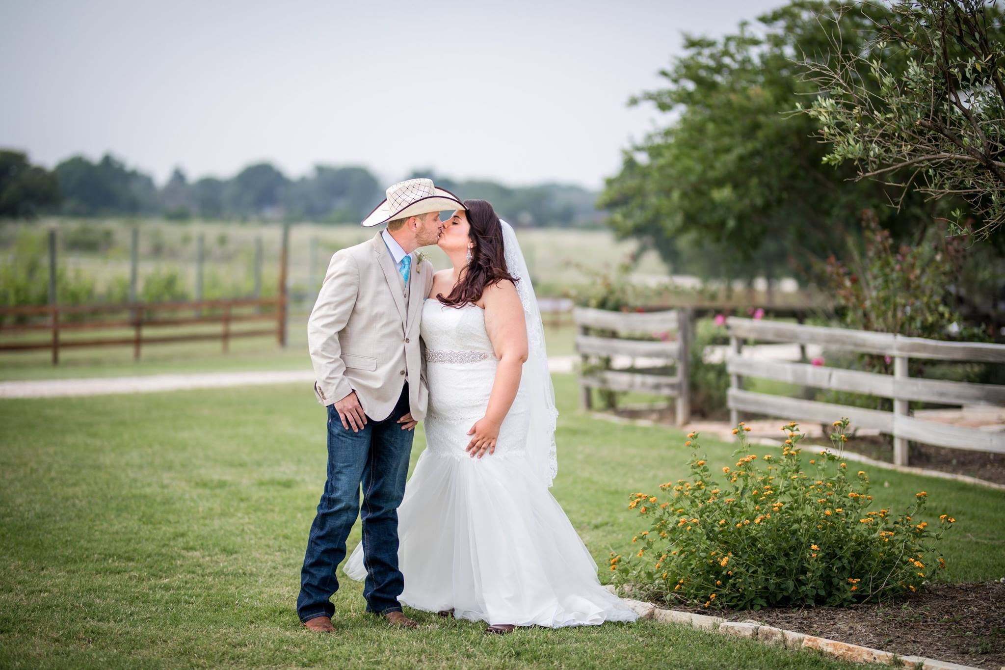 Couple standing together beside a fence on the estate lawn