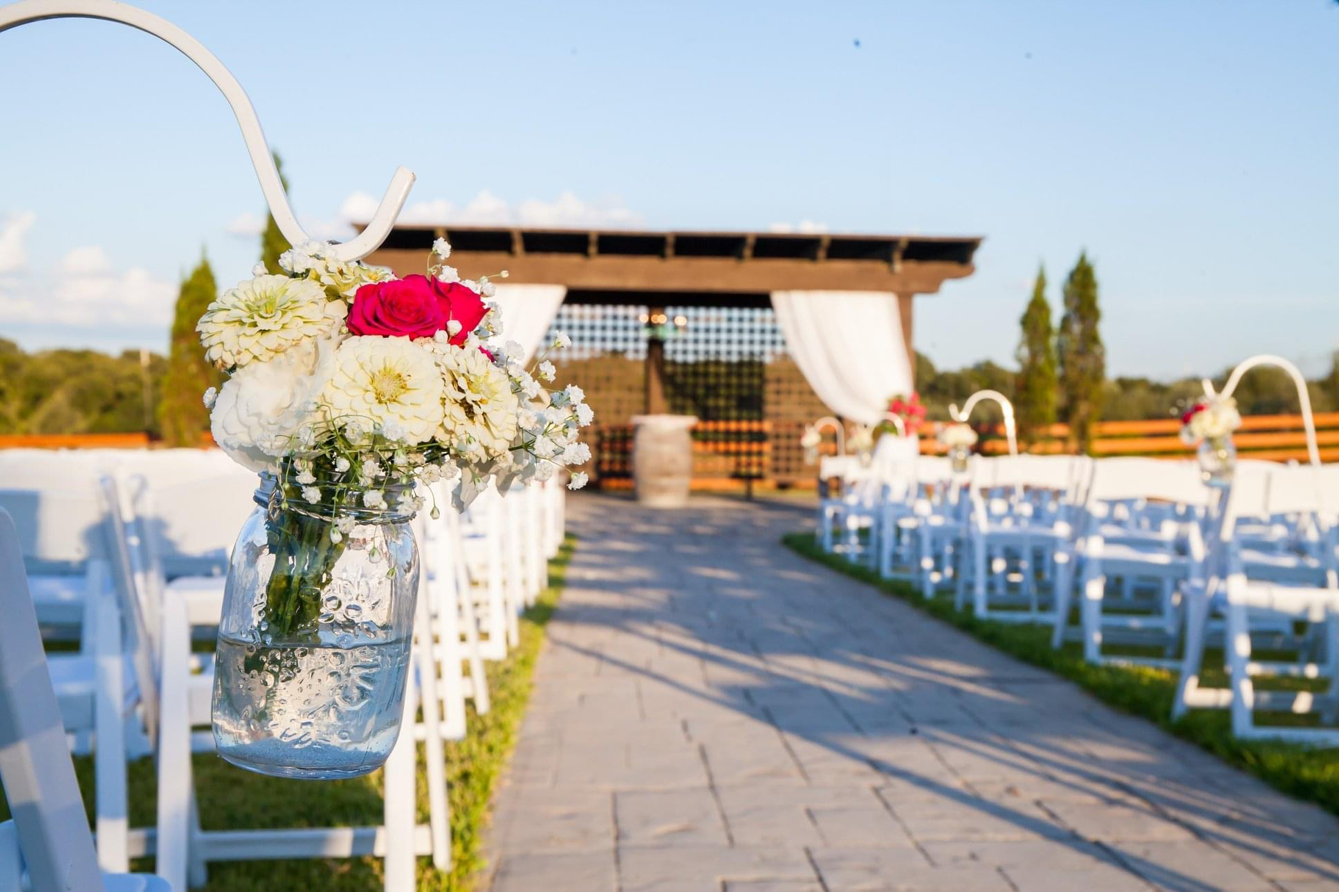 Outdoor wedding ceremony aisle with floral arrangements at Red Rock Vineyards