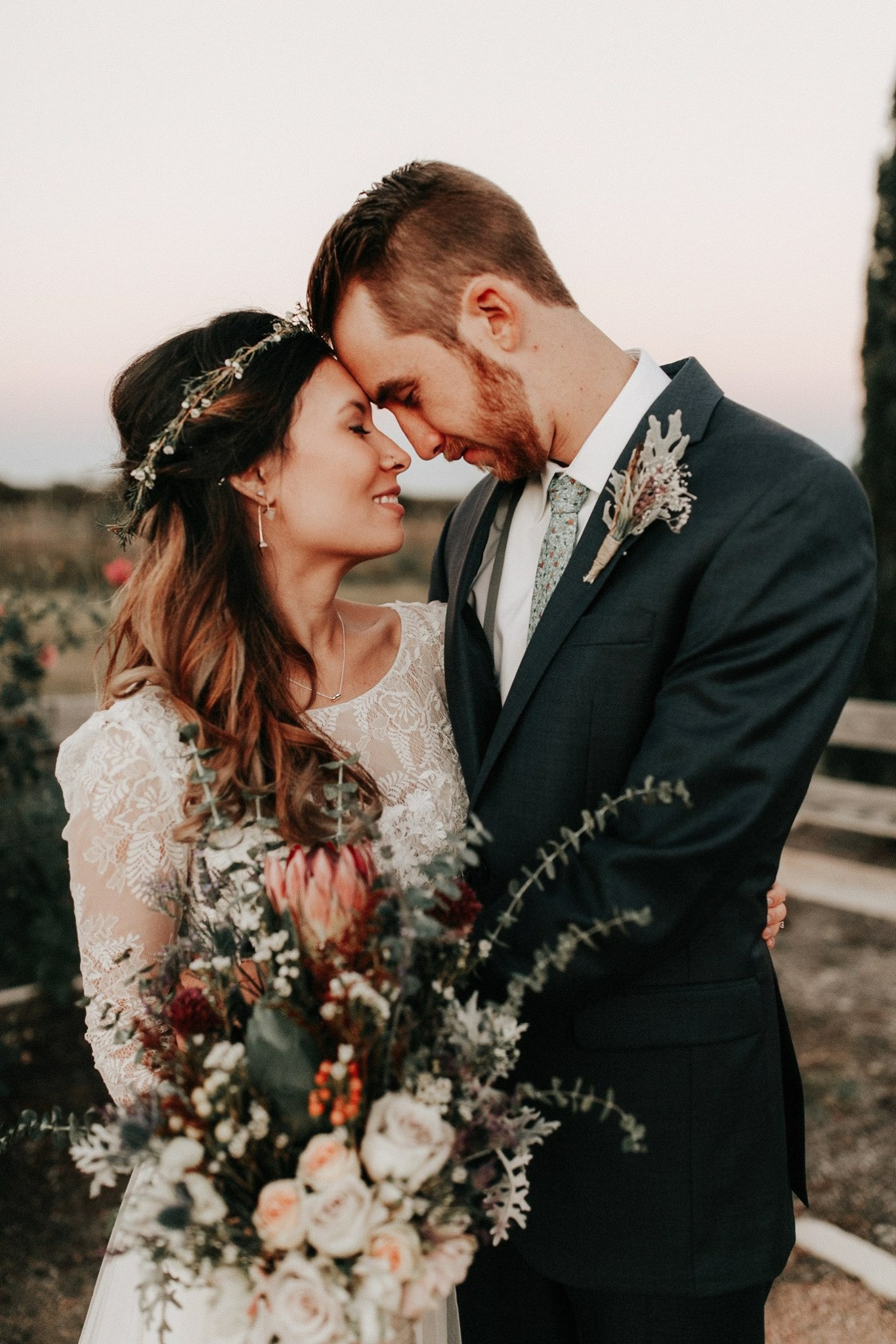 Newlyweds holding each other with a floral bouquet